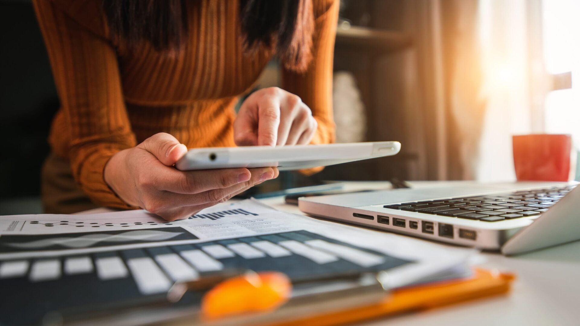 Businesswoman hand working digital marketing media in virtual screen with mobile phone and modern compute with VR icon diagram at office in morning light