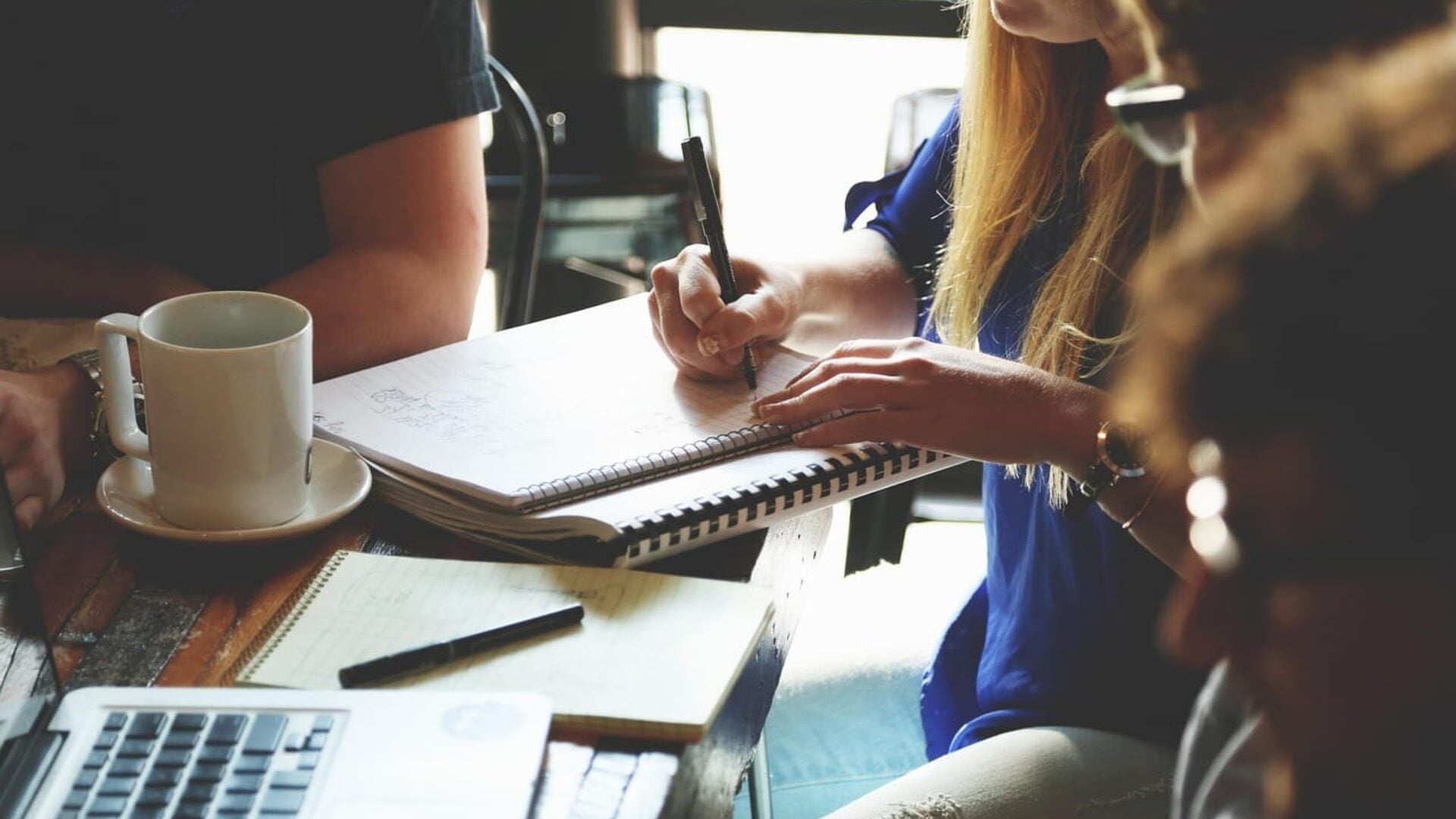 woman taking notes in a coffee shop